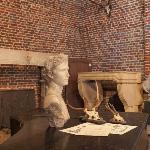 Antike Kaminmasken aus Kalkstein in unserem Showroom